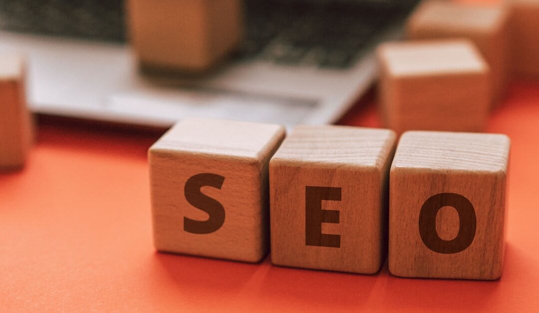 Wooden blocks spelling SEO on a laptop keyboard convey digital marketing concepts.