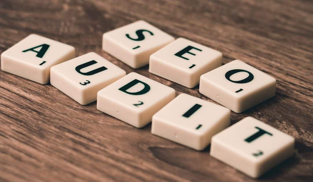Scrabble tiles spelling SEO Audit on wooden surface, symbolizing digital marketing strategies.