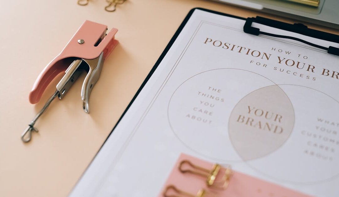 Pink stapler and branding document on a desk showcasing stylish office setup.