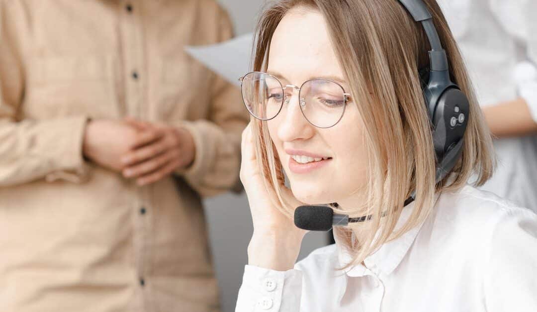 Professional woman providing customer support with a headset in an office setting.