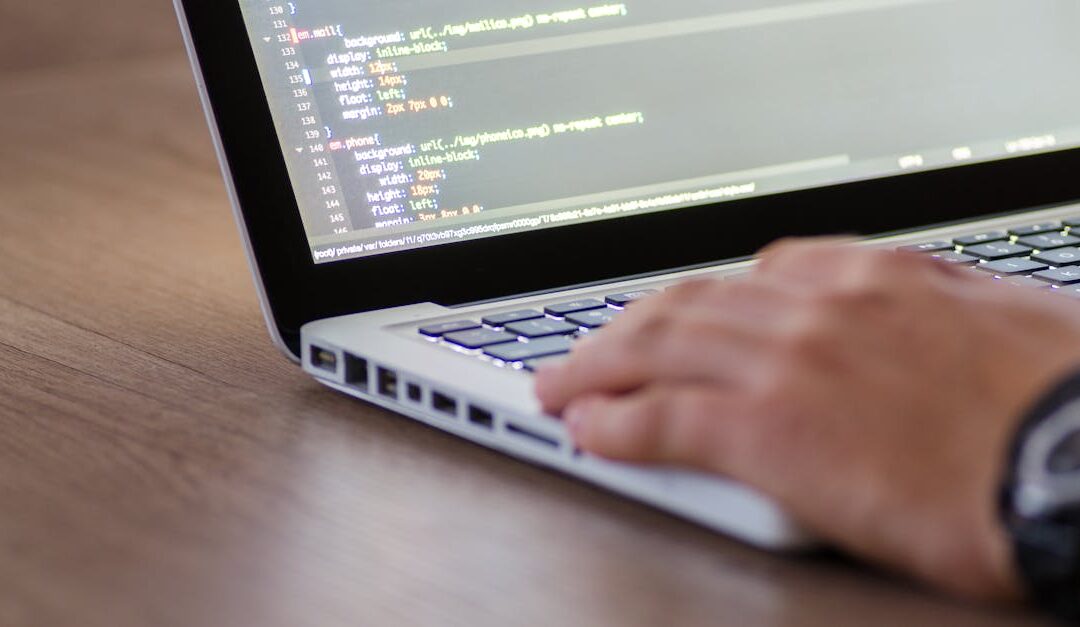 Person coding on a laptop with HTML code on screen, showcasing development work.
