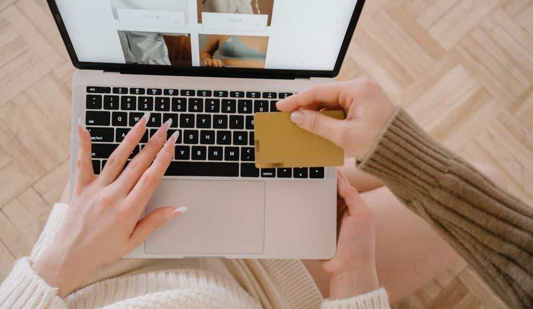 Person shopping online using a laptop and credit card, highlighting e-commerce convenience.
