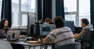 Team of developers working together on computers in a modern tech office.