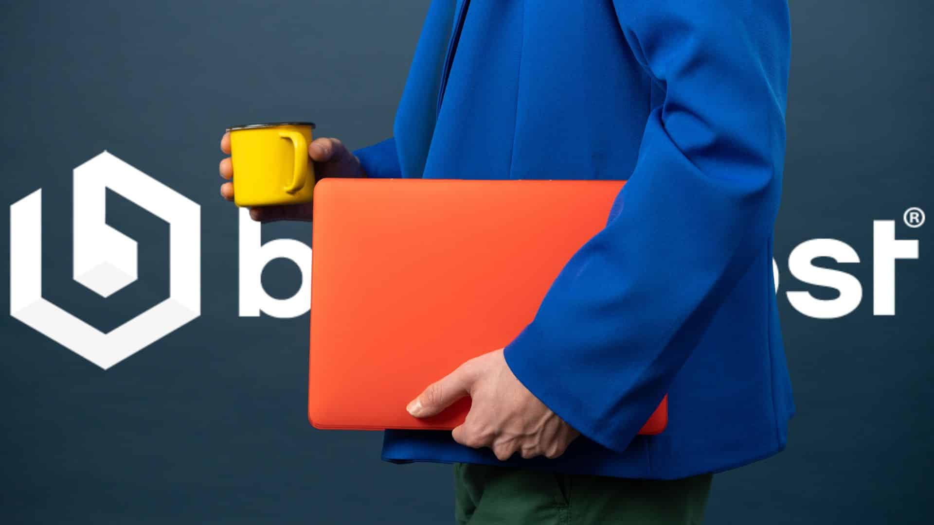 Person in a blue suit holding an orange laptop and yellow coffee mug in front of the BaseHost logo, symbolising managed IT services and business technology solutions.
