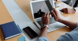 Close-up of a business meeting with laptops and smartphones, focusing on teamwork and digital collaboration.